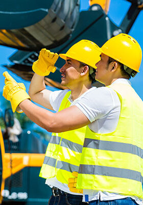 Construction workers inspecting equipment